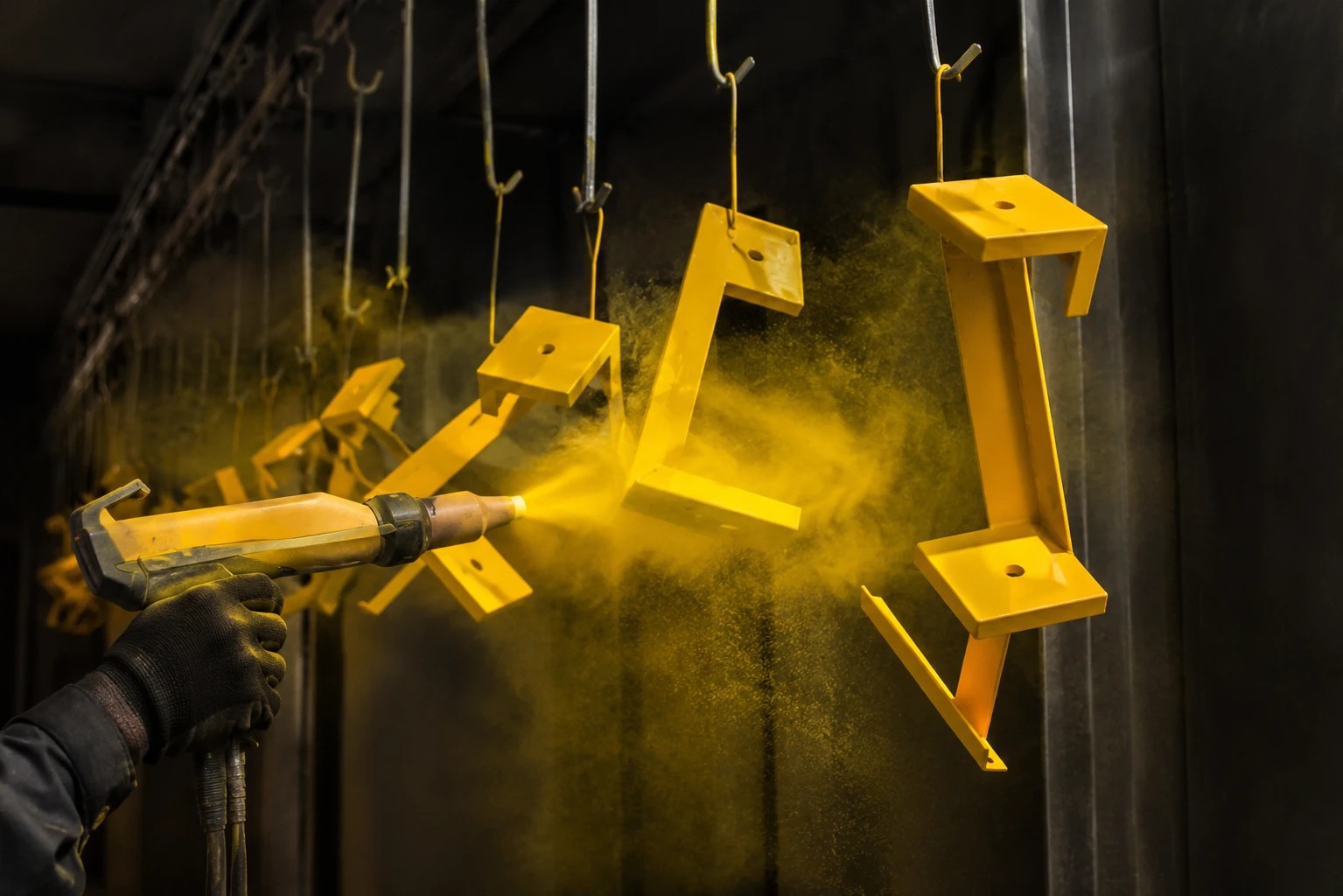 Powder coating being sprayed on steel parts at AmeriSteel in Warren, Michigan